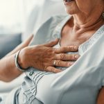 Mature woman experiencing heartburn while on the couch